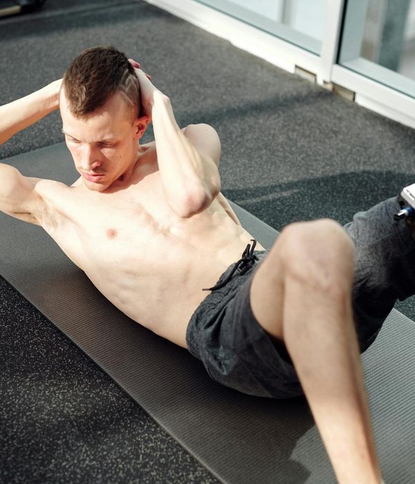 Strong man practicing focused abdominal exercises in a dark atmospheric gym